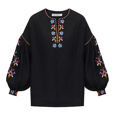A black, long-sleeved blouse with voluminous puff sleeves and a round neckline, featuring intricate, colorful geometric and floral patterns in blue, red, orange, and white embroidered down the chest, along the shoulders, and around the cuffs