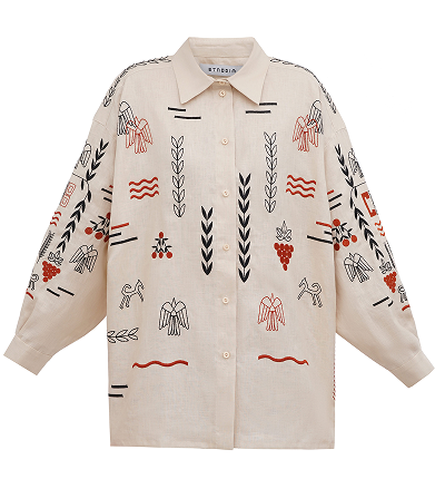 A cream-colored, long-sleeved button-down linen shirt with a pointed collar featuring a scattered rustic embroidery of stylized birds, horses, and botanical motifs in terracotta and black